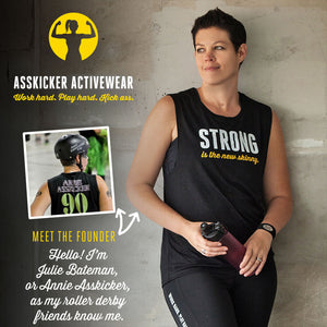 Julie Bateman is the female founder of Asskicker Activewear - a retired roller derby skater named Annie Asskicker. Black muscle tank that says Strong is the New Skinny.