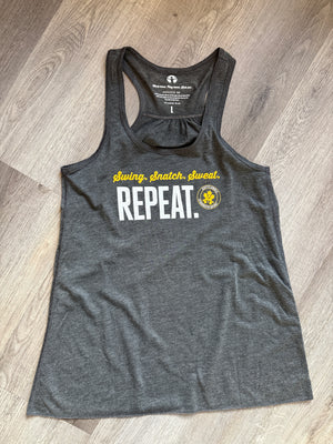 Gray tank top with text and logo on a wooden floor