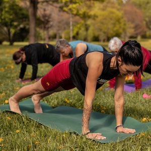 Yoga instructor modelling a cropped yoga tank top, in high plank position.