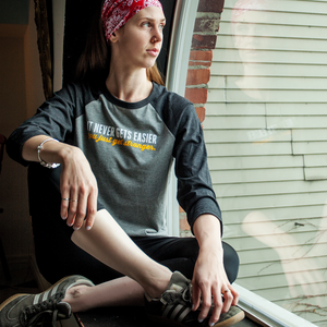 It never gets easier, you just get stronger. Baseball tee for woman, lifestyle photo.