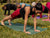 Fitness instructor demonstrating the plank position in a core and ab fitness class