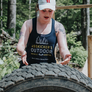 Young woman flipping a tire during Asskicker's First Annual Outdoor Obstacle Adventure for Women.