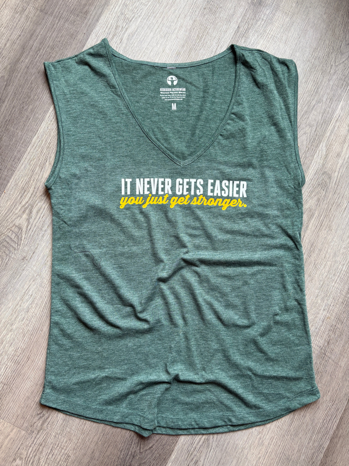 Green tank top with text on a wooden floor