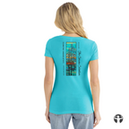 A woman models a slim-fit V-neck tee featuring a landscape painting by Denice Bustraen against a neutral background.
