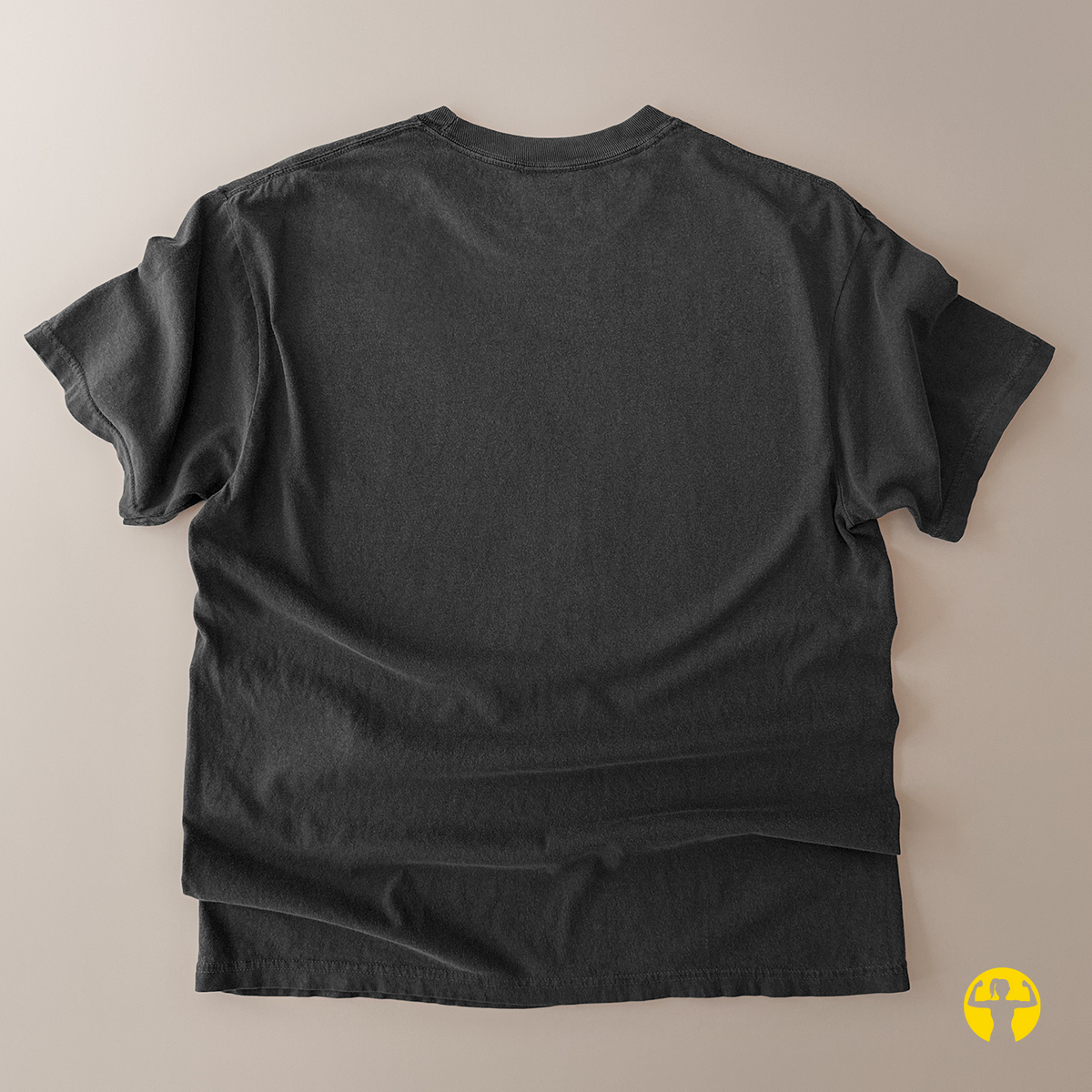 A dark charcoal gray short-sleeve t-shirt shown from the back, laid flat on a solid beige background.
