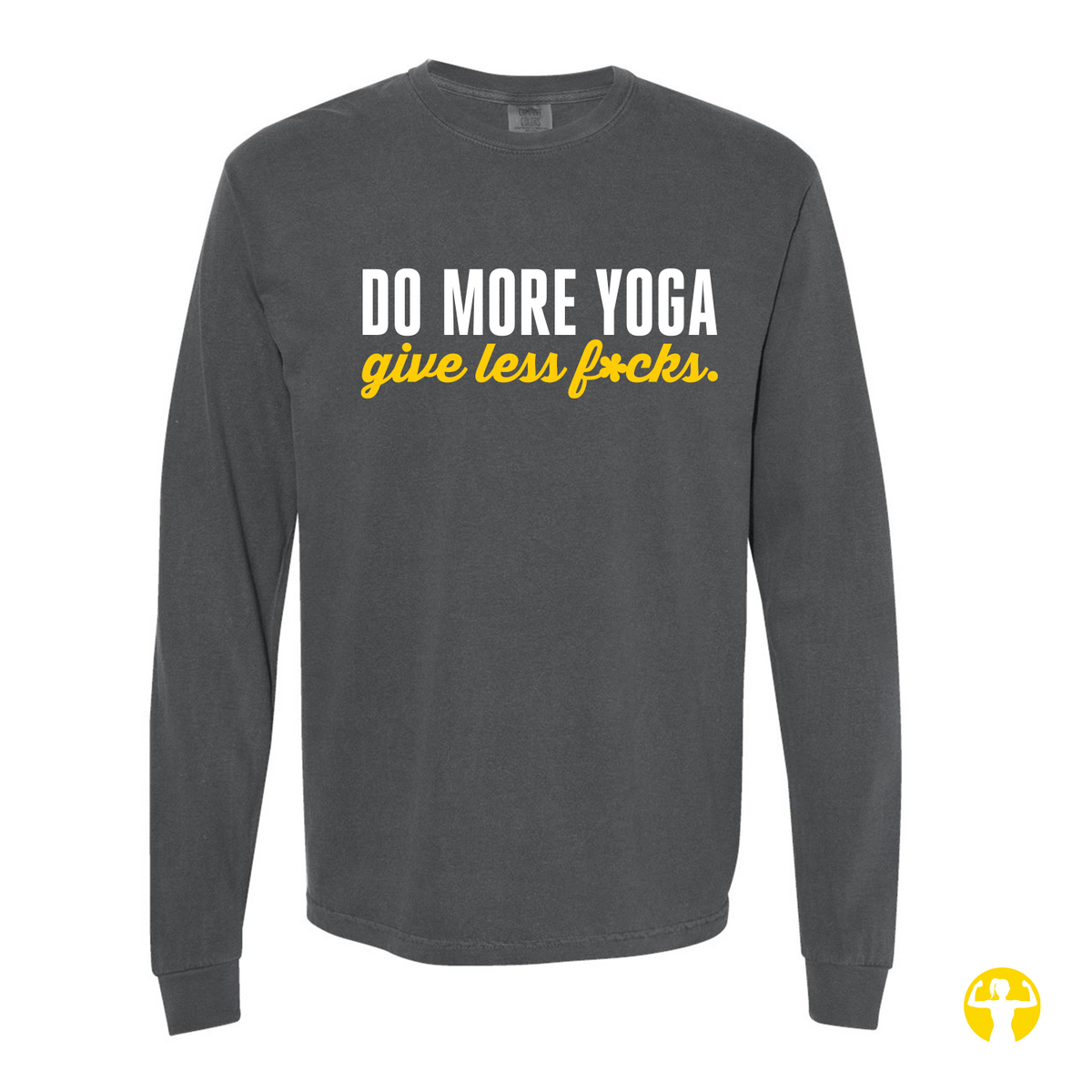 Flat lay view of a charcoal gray Pepper-colored Comfort Colors long sleeve shirt featuring the text 'Do More Yoga, Give Less F*cks' printed across the chest in bold white block lettering and bright yellow script, on a light beige background.