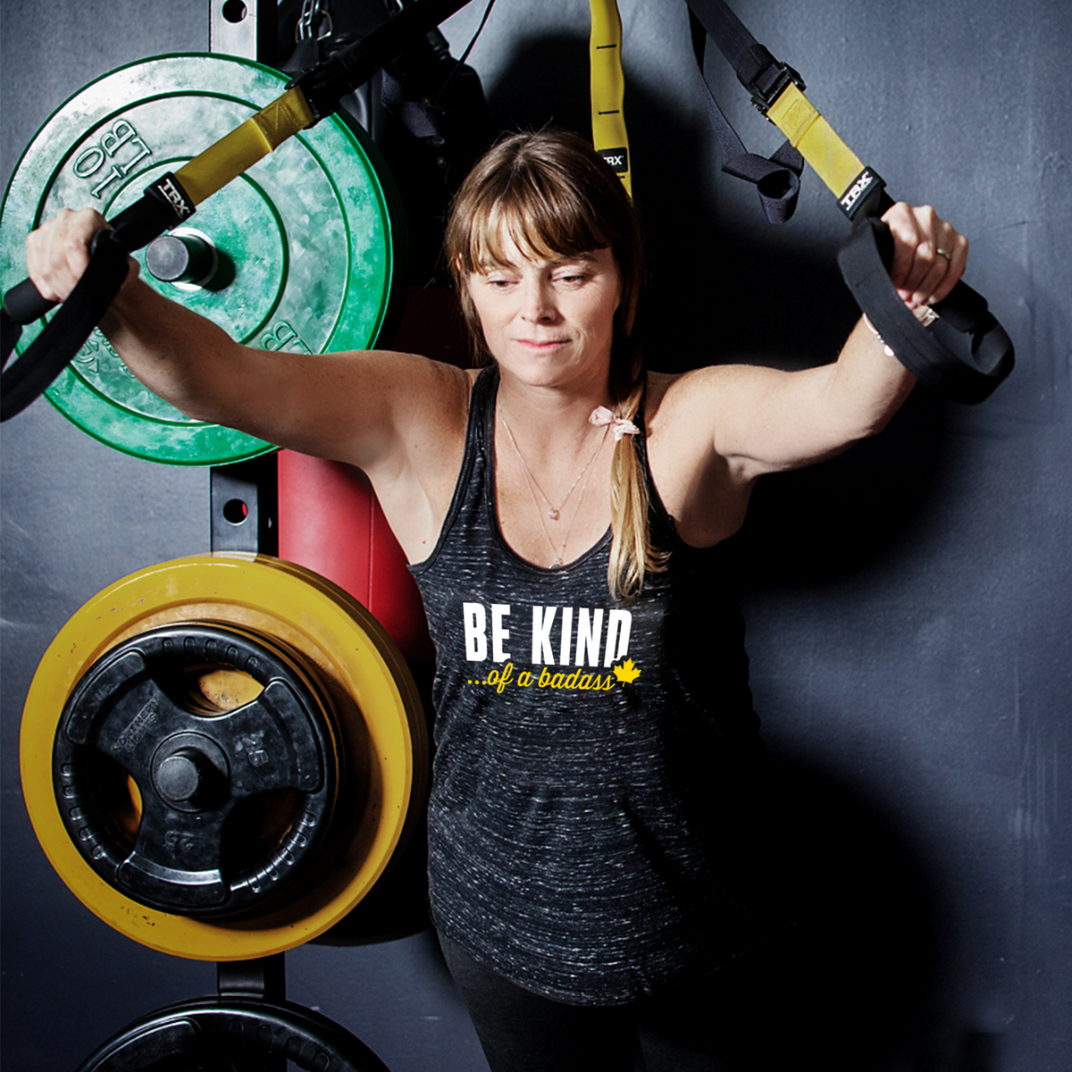  BE KIND ... of a Badass - Ultra Soft Flowy Racerback Tank Top. We're a small Canadian clothing brand  for women that specializes in ultra soft gym tanks, graphic tees and casual wear with empowering messages—designed to fit all body types. Free curb-side pickups are available in Barrie, Ontario. The flowy racerback is our most popular style because the fabric feels ultra soft and the draped silhouette is flattering on all body types. Perfect for the gym or casual wear, the light fabric dries quickly.