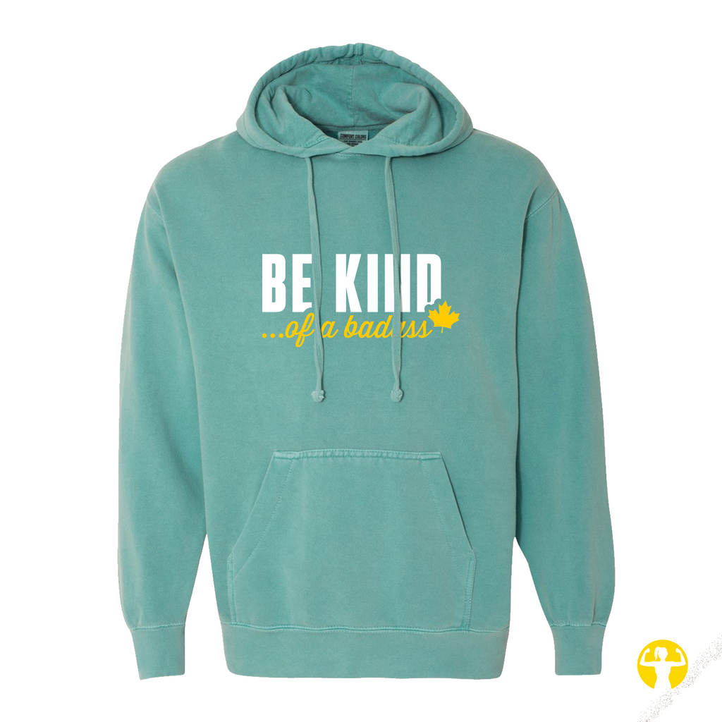 A teal-green pullover hoodie with a front kangaroo pocket and drawstrings, featuring the text 'BE KIND... of a badass"