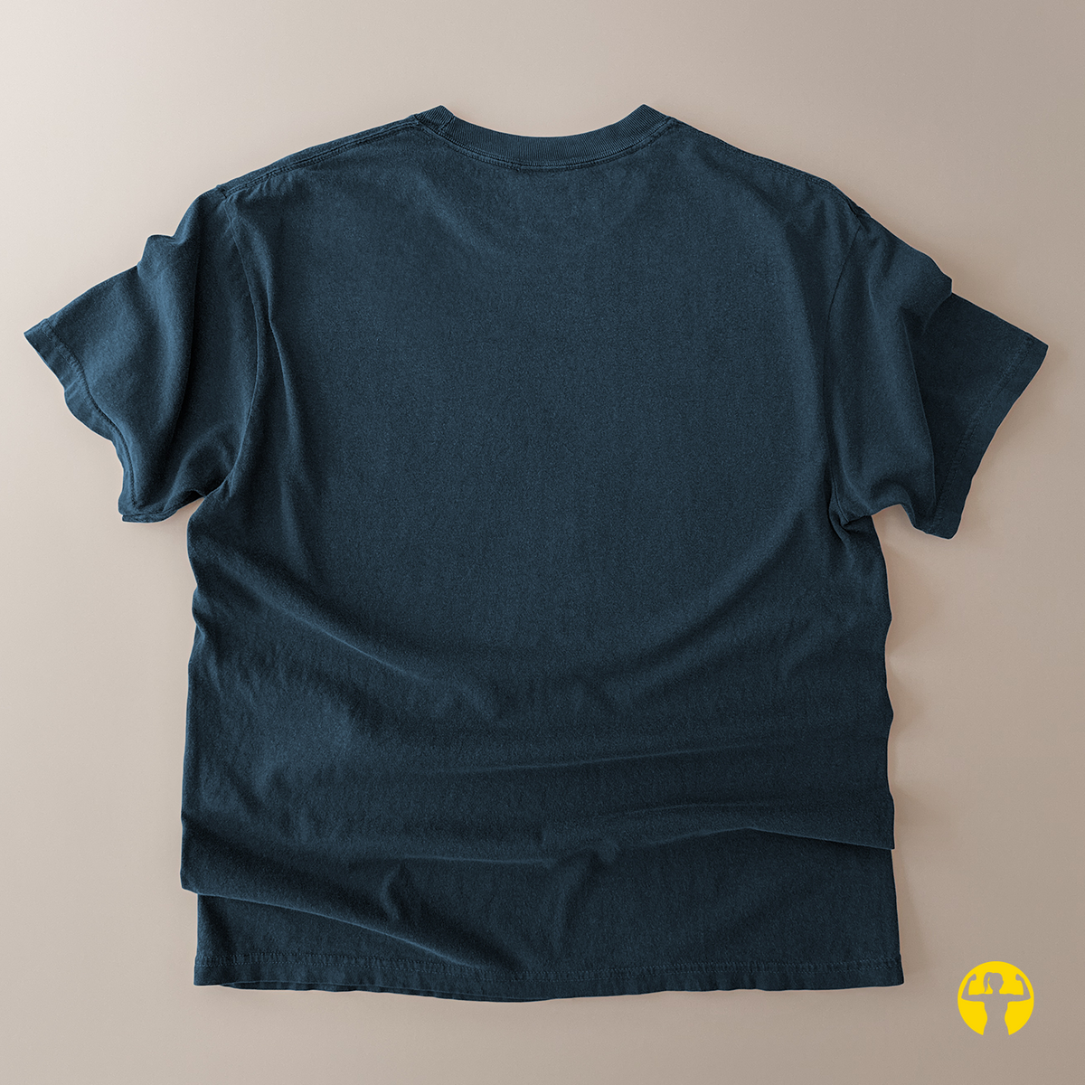 A dark teal blue short-sleeve t-shirt laid flat on a light beige background, showing the back side with natural fabric folds.