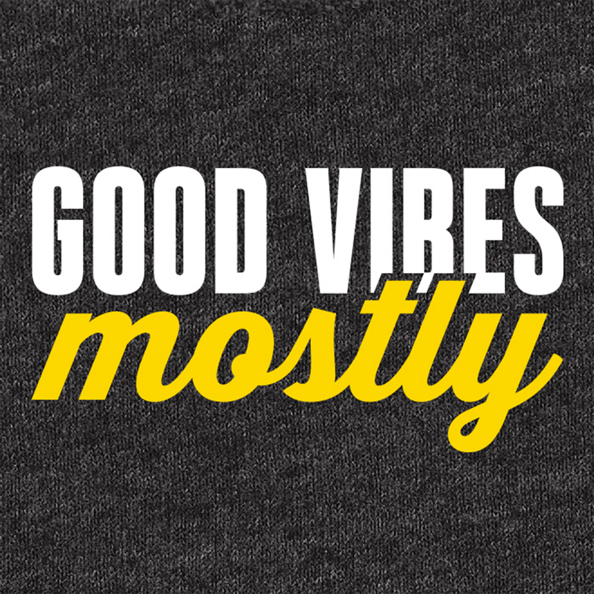 A close-up of a dark heather gray fabric surface with printed text reading 'GOOD VIBES mostly' in white and bright yellow lettering.