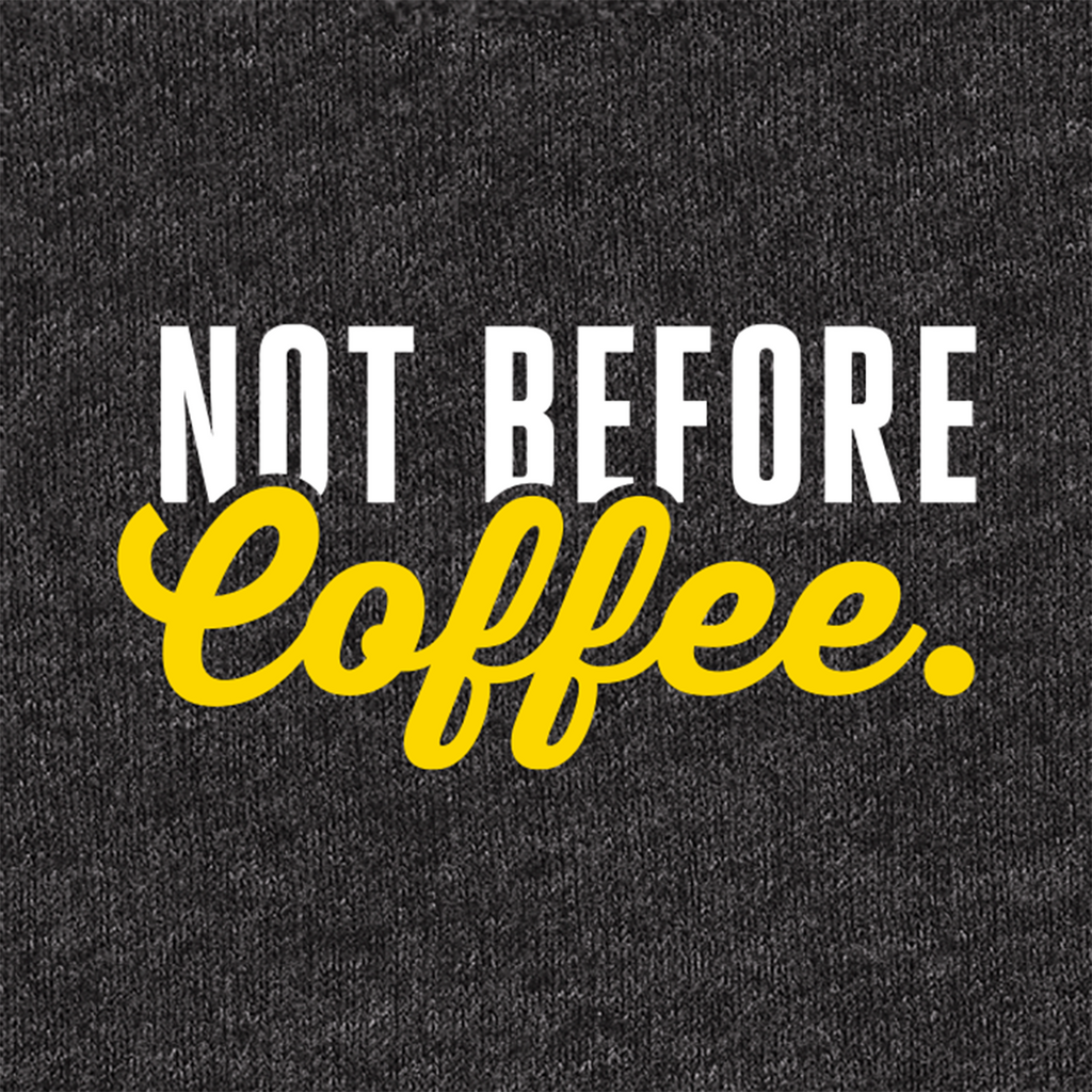 A close-up of a dark heather gray fabric with a printed slogan reading 'NOT BEFORE Coffee.' in white and bright yellow lettering.