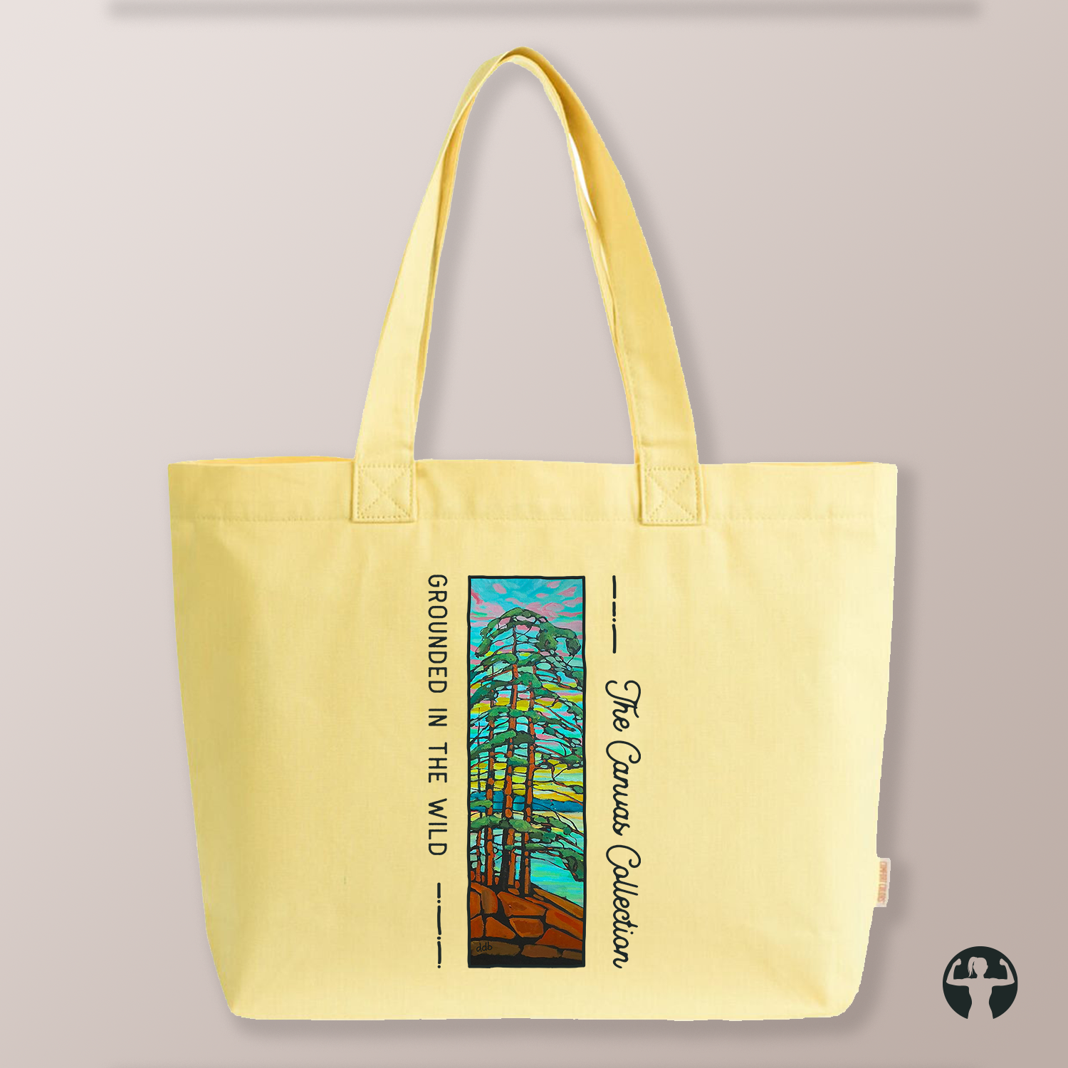 A light yellow canvas tote bag with dual shoulder straps, featuring a printed graphic of a forest on the front. The graphic includes the text 'GROUNDED IN THE WILD' and 'The Canvas Collection"