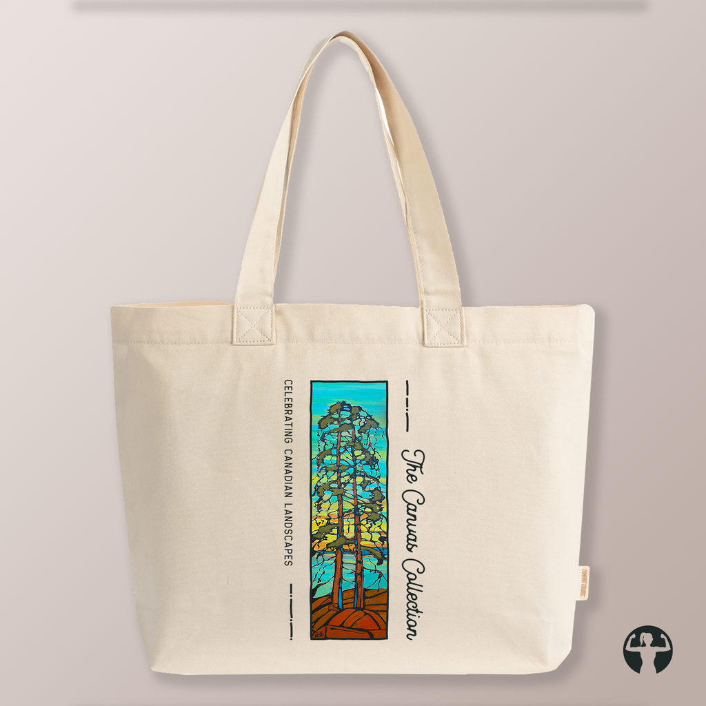 An off-white canvas tote bag with dual shoulder straps, featuring a colorful graphic print of a pine tree and the text 'The Canvas Collection' and 'Celebrating Canadian Landscapes' on a neutral beige background.