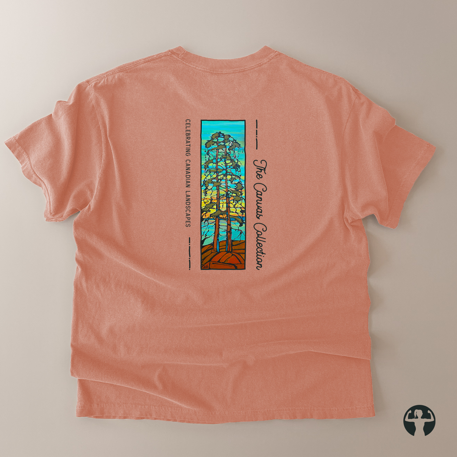 A peach-colored short-sleeve t-shirt laid flat on a light beige background, showing the back side with a colorful graphic of a tree in stained-glass style and the text 'The Canvas Collection' and 'Celebrating Canadian Landscapes'.