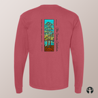 A long-sleeve t-shirt in dusty rose pink, shown from the back. It features a vertical graphic print in the center depicting stylized trees with a teal sky, yellow and green foliage, and an orange-brown ground.